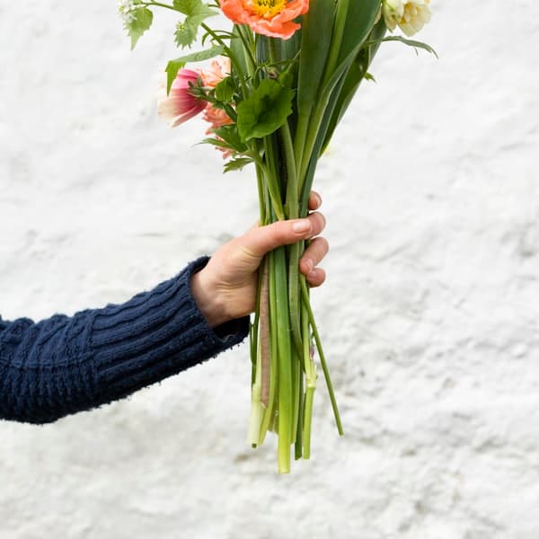 Person mit einem Blumenstrauß in den Händen